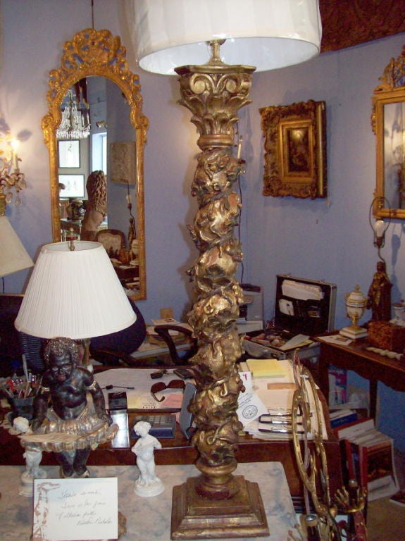 A pair of carved twisted wood columns in paint and gilt decoration now mounted as lamps.