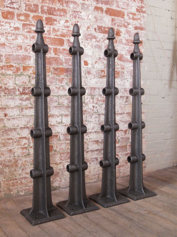 Set of four vintage Industrial cast iron posts. Measures: 43 1/2" in height, base measures 8" x 8". Hole openings measure 1 7/16".