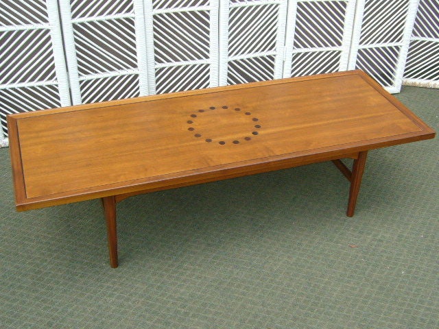 SOLD  From the Declaration Line, this long walnut coffee table by Kip Stewart has a circle of rosewood button inlays in the center and ebony inlaid stringing along the inner moulded edges.  Great long board scale with its five foot length.  In