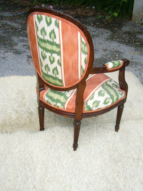 ...SOLD FEBRUARY 2012...Beautiful Mid 19th Century Louis XVI Walnut Fauteuil upholstered in Ikat Moire.  Heavily carved with ribb and floral crest back, acanthus leaf s scroll arm supports, ribband apron, fluted tapering legs with toupie feet and