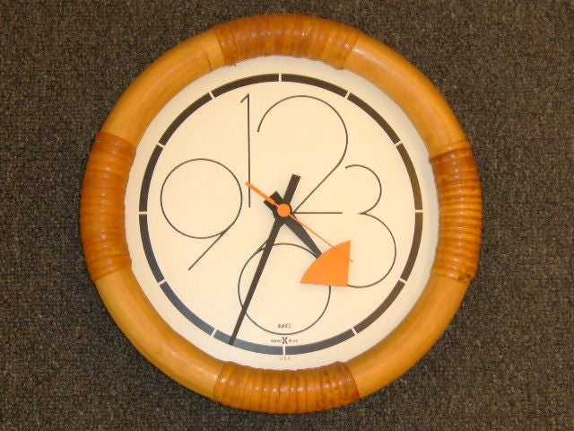 Rattan rules in these two mid century clocks from the vast catalog of designs by George Nelson & Associates for Howard Miller.  Both with white dial face and black numerals with orange or orange and black hands. In excellent original condition. 