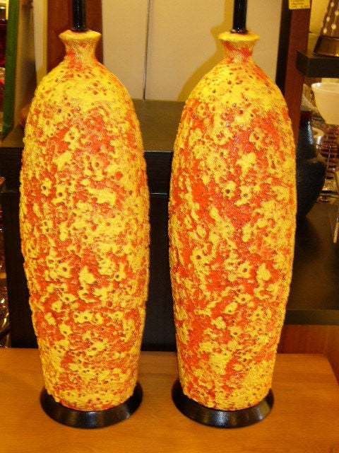 Reduced from $950....Incredible 1950s Mid-Century pottery lamps with an orange and yellow bubbly Lava glaze finish. Great elongated vase form with ebonized wood socle bases. Fun Natzler and Hot Lava inspired lamps! Just add your shades. 
Price is