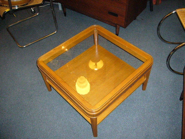 Beautiful coffee side table, streamline modern with inset glass top and stretcher shelf. Square in shape with smooth curved corners. Great color and finish. Darn nice!

