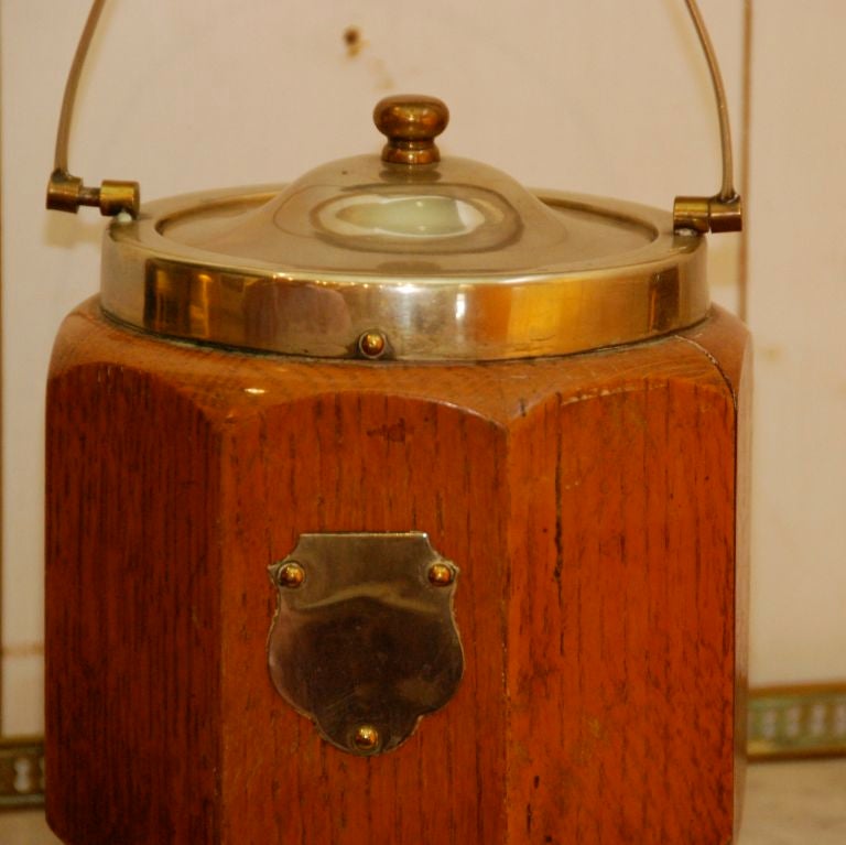English biscuit barrel with ceramic insert. The barrel also has a silver plate lid, handle, and plaque.