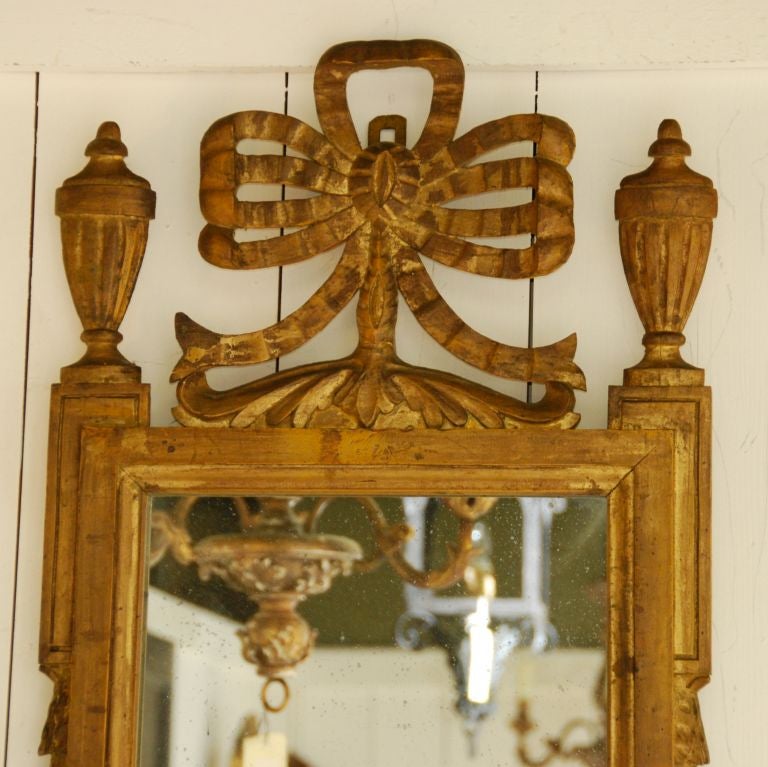 Gilded mirror with urn & ribbon top