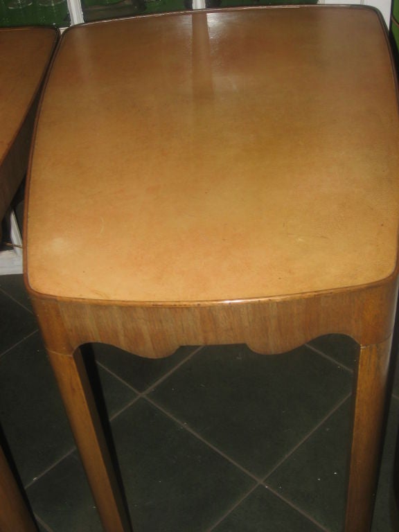 Pair of Unique Side tables have a wonderful apricot cream leather top. The legs taper into arrow shapes. Tops are slightly pie shaped.