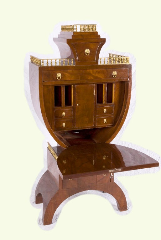 The lyre shape of this secretary gives it a strong,  almost contemporary sculptural feeling.  A gallery at the top and two side sections provides a bit of extra detailing to the piece that makes it beautiful when it is closed. When the desk-top is