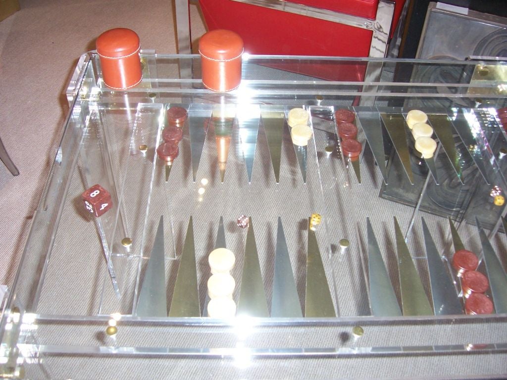 This is a complete set w/ all bakelite game pieces and leather tumblers.  Simply remove glass to play and replace for table top use. Thick lucite and brass trim.
