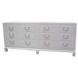 A White Lacquered Raffia Covered Double Commode by Baker