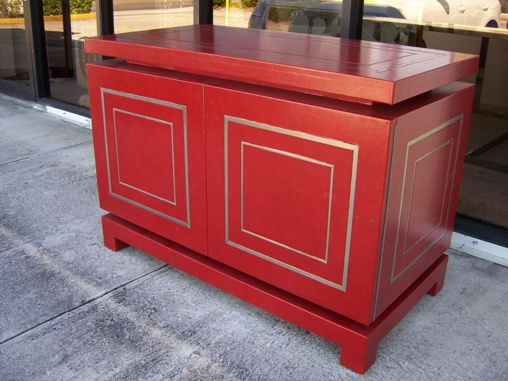All original crackled Hermes red leather with heavy steel frame details throughout.  Two-doors open to interior shelf also in red.  ALL exterior is wrapped in leather.  ALL original - great craftsmanship. Attributed to Maison Jansen.