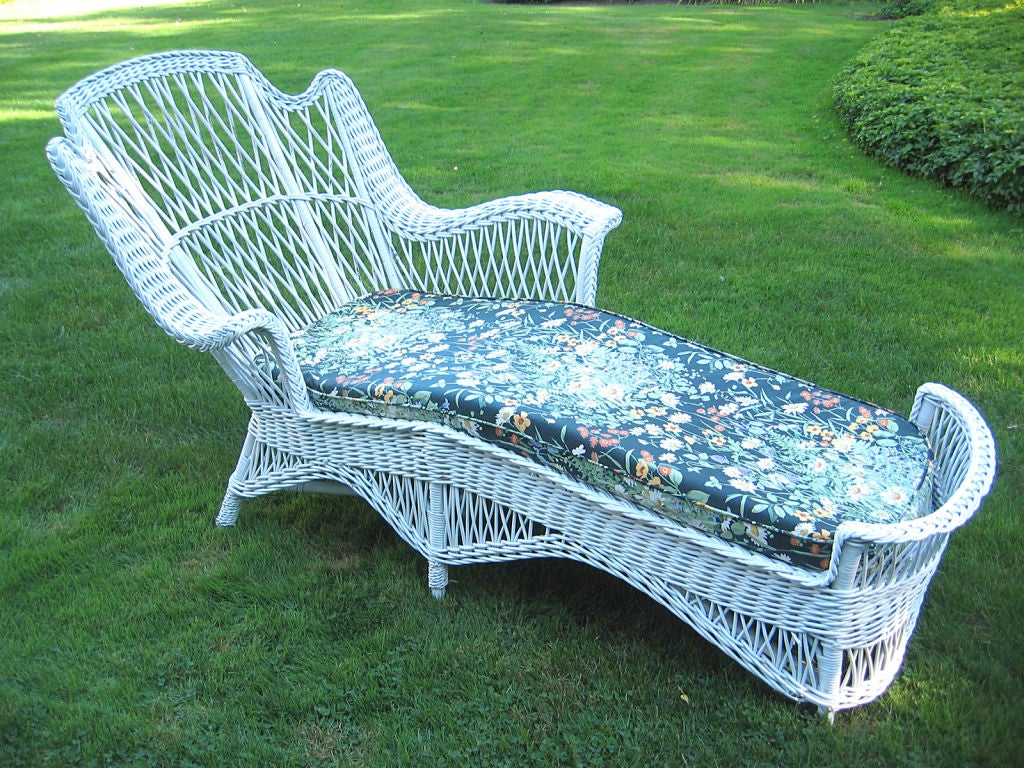 Unusual winged Bar Harbor racamier chaise longue painted white.  Grand scale with dramatic curved arms, rounded footrest and arched skirting.  Hallmark Bar Harbor latticing overall. CORNER HOUSE ANTIQUES offers an extensive inventory of American