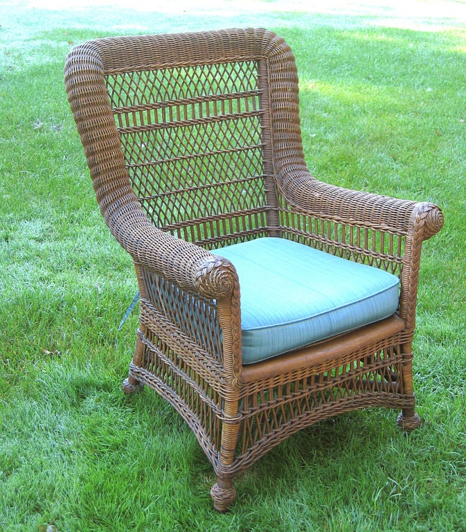 American antique wicker Victorian armchair made by Heywood Wakefield in the 1890s.  Original natural stained finish.  Traditional style with continuous serpentine roll to squared back and arms, ending in decorative woven rosettes. Four twist-wrapped