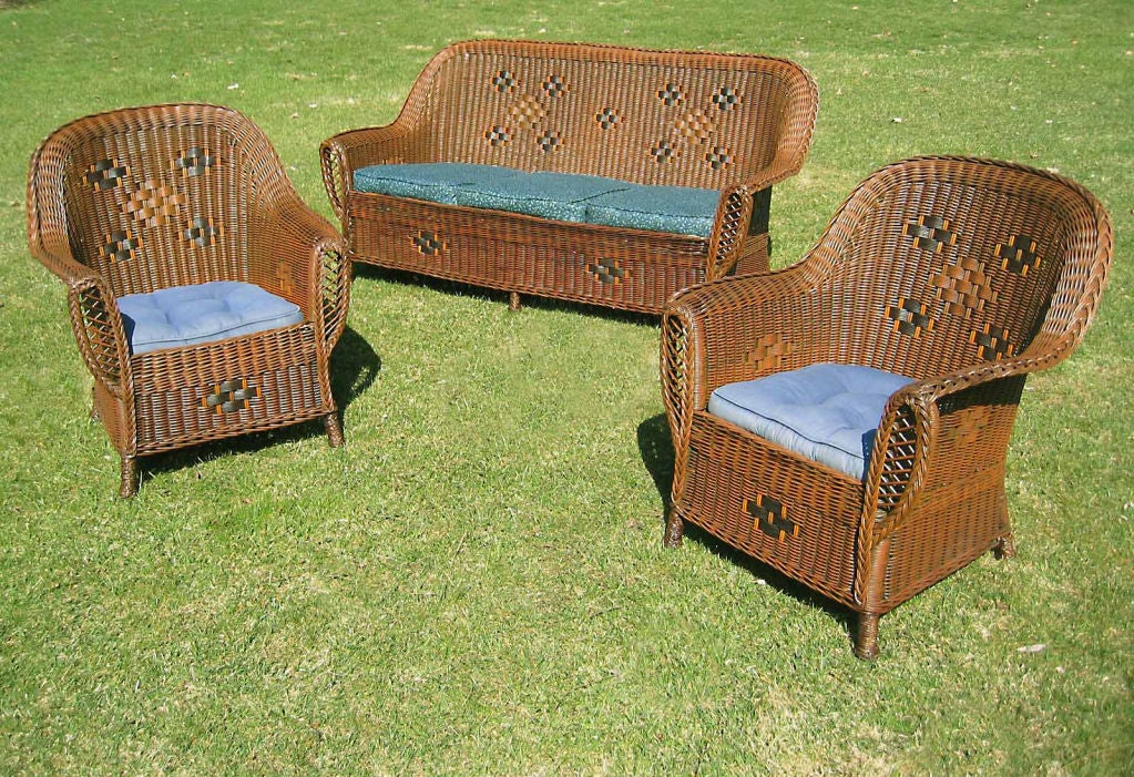Three-piece Art Deco wicker set in original duo-toned finish with detail highlighted in contrasting colors.   A fine example of high style American antique wicker made by the Heywood Wakefield Co. circa 1920.  Matching set includes sofa and two