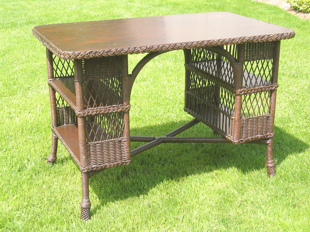 Bar Harbor wicker library table in original dark natural stain with age appropriate finish wear (can be re-finished on request). Double level bookshelves at each end, 27