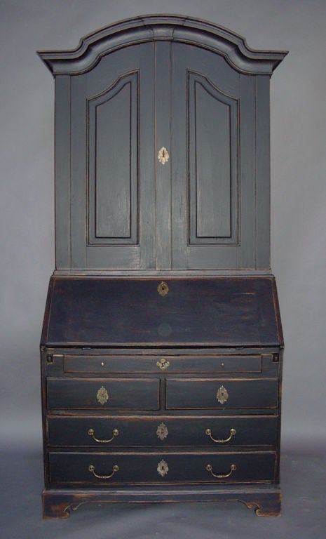 Baroque Swedish secretary, circa 1770, in black paint. Top section has three shelves behind two paneled doors. Lower section has five drawers below the slant front. Inside are 12 small drawers and 7 cubbies. Original hardware. (Depth 34½