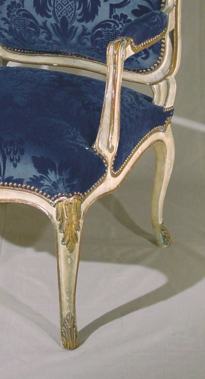 Each with flower carved cartouche back, padded arms, serpentine seats and cabriole legs