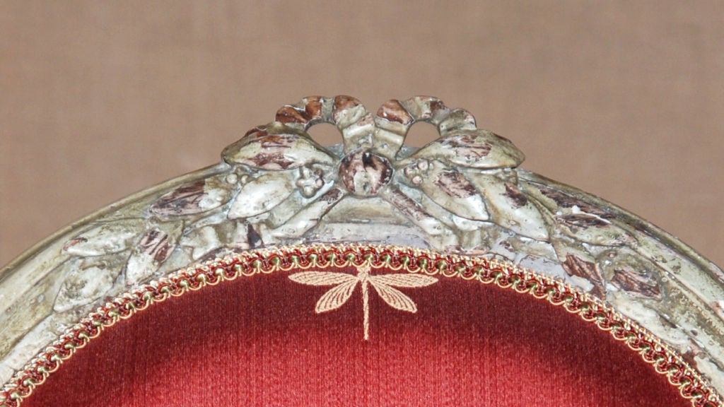 Each oval back (dossier medaillion)with bow-knotted laurel crest, the padded arms on s-scroll supports, and the bow-fronted seat above laurel carved rail, raised on stop fluted legs