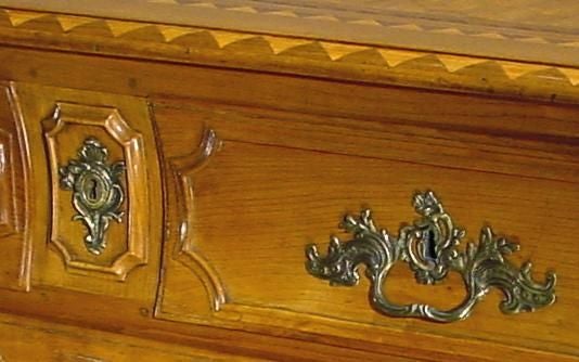 Attribuito a Jean Francois HacheIl piano rettangolare in parquet con bordo modanato, sopra una cassa a bombe con due cassetti corti e uno lungo a pannelli, sopra un grembiule smerlato, sollevato su gambe cabriole.