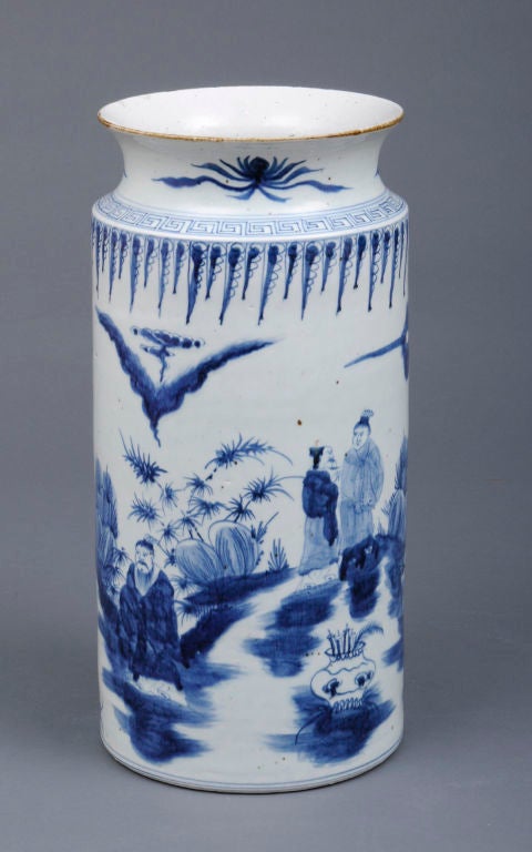 Large Chinese blue and white cylinder-shaped vase with concave shaped top, decorated with figures and trees around a body of water. Would make a great umbrella stand.