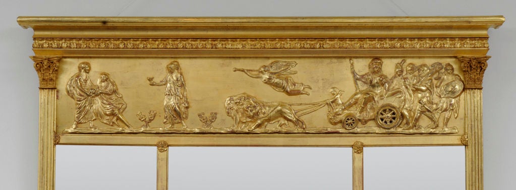 Victorian giltwood overmantel mirror with three beveled mirror plates, a frieze with applied classical decoration of lions pulling a chariot, soldiers, putti and muses below molded cornice, reeded flat columns topped by Corinthian capitals.