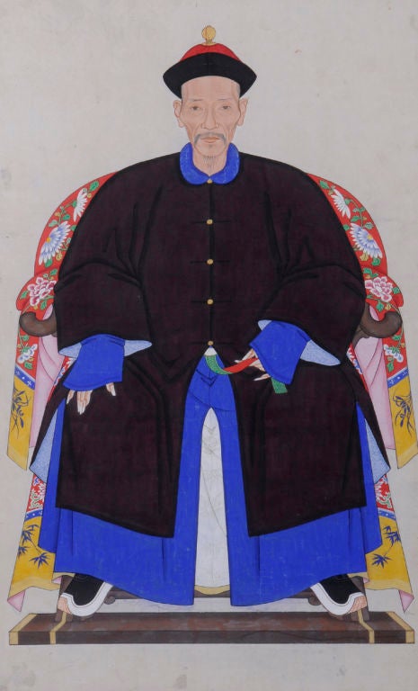 Chinese single ancestor portrait of Mandarin gentleman wearing winter costume with colorful silk kimono covering the back of the chair. Ink on paper. Silver leaf frame with red inner mount.