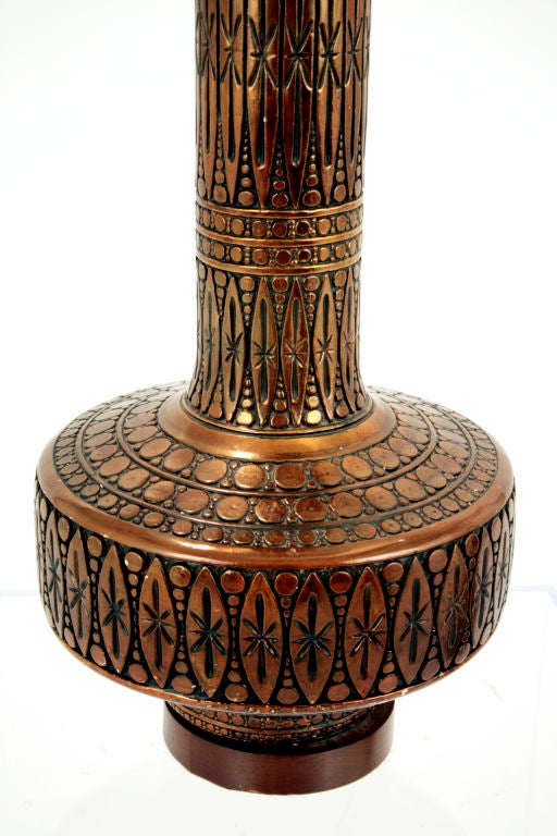 A pair of intricately detailed copper ceramic table lamps resting on a wood base.