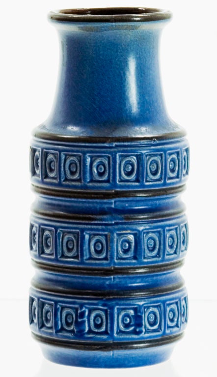 A cobalt matte-glazed vase featuring three tiered rings of a circle-in-square pattern. A chocolate glaze finishes the vases' interior. Marked on its base is 