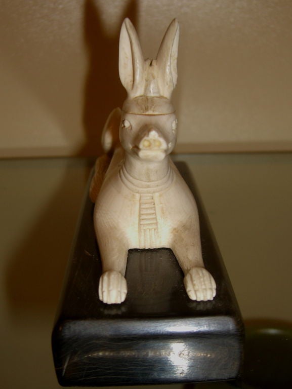 A nicely carved Ivory figure of Anubis in his dog form on what I believe is a semi precious hardstone base like agate. It most likely dates form the mid 1920's when Howard Carter opened Tutankhamen tomb's and such Egyptian revival items were