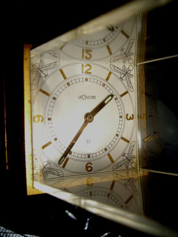 A great clock by the world re-known firm of Jaeger Le-Coultre, maker of some of the world's most luxurious clocks and watches. This clock is in the form of an Egyptian Obelisk and has a lucite top. The gold metallic Egyptian scenes repeat on all