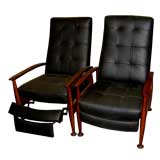 An unusual pair of mid century recliners black leather & walnut