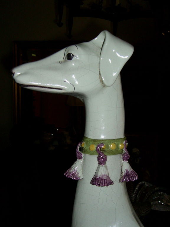 A nice life size majolica figure of a greyhound. It is signed CVE and made in Italy. There are repairs to the front legs and a chip to the front left corner. It is extremely well rendered and colorful.