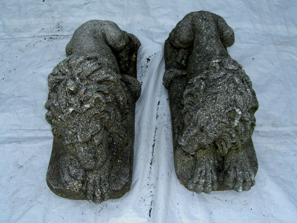 A great pair of recumbent lions cast in a great stone with large pebbles and glinty stone. There are quite heavy. One has damage to it's tail. They are a matched pair facing one another, or you you align them the other way as well.