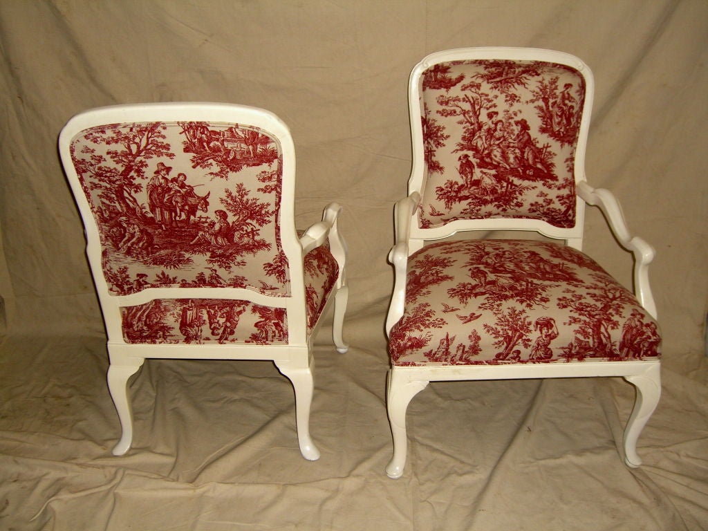 A great pair of White lacquered Queen Anne style armchairs with beautiful cotton Toile upholstery. The chairs have horsehair and spring interior construction. They are generously sized and comfortable.