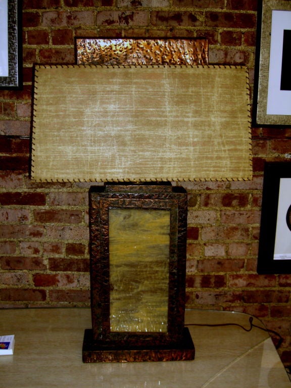 A unique 1950's copper hand hammered sheeted lamp with it's original shade. It features a piece of stained glass in the front panel which is back lit. the top assembly screws off to replace the interior bulb. The shade is original and features a