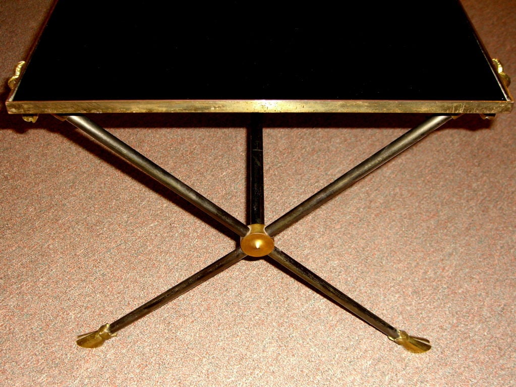 A nice little coffee table with a black glass top and ram's heads in each corner. The table is very much in the style of Maison Jansen.