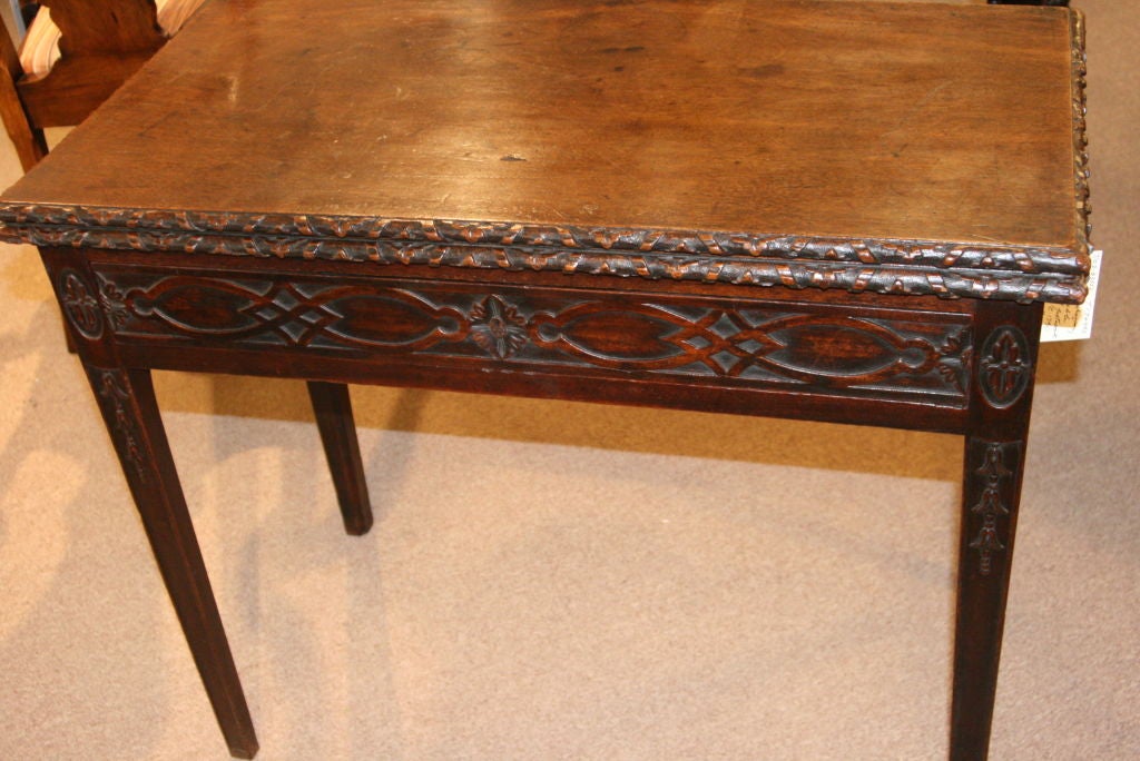 18th Century Mahogany Game/Tea Table with blind fret work. Foliate surround plus Adam style swags on tapered legs.   Fold over top with brass hinges supported by gateleg. Gadrooned edges. Excellent patina when closed or open.   Size: Closed 29ins