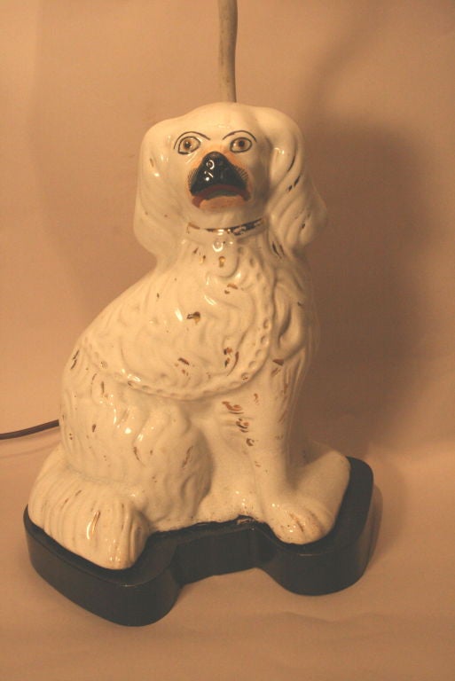 Staffordshire Spaniel Dog converted to lamp on stand. The original antique condition of the Spaniel has been retained and the lamp base and rod accommodated so as not to detract from it's value.  The Shade is White silk lined and accented with black