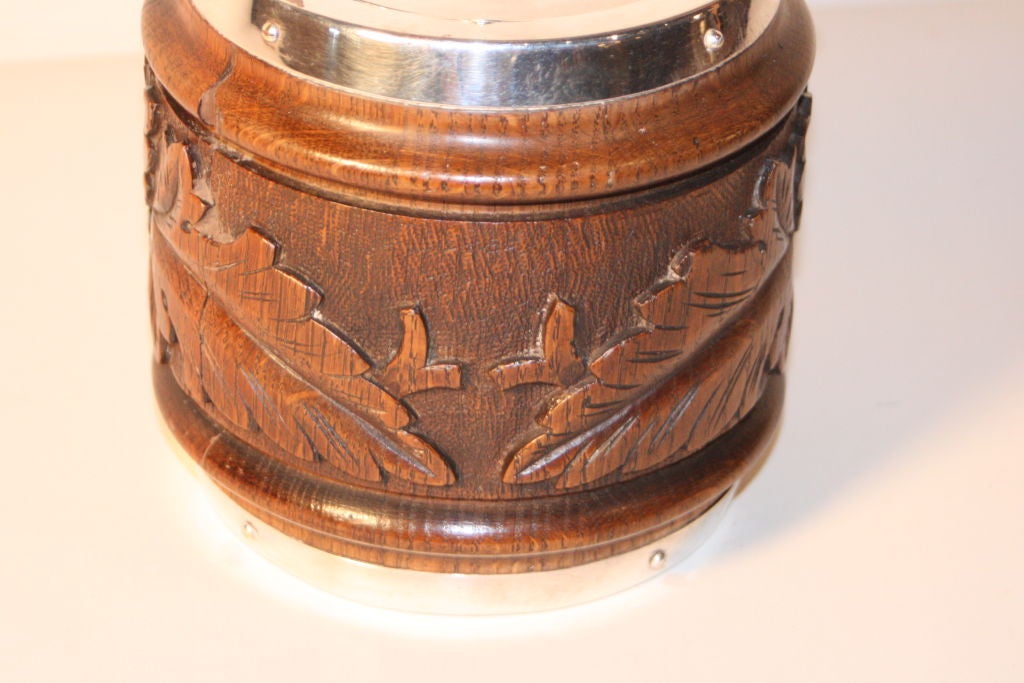 English carved oak and silver-plate biscuit barrel, porcelain lined.   Oakleaf carving with an old crack as shown (minor).<br />
Shield cartouche unmarked.  Lid stamped 'epns'.<br />
FREE SHIPPING to lower 48 States.