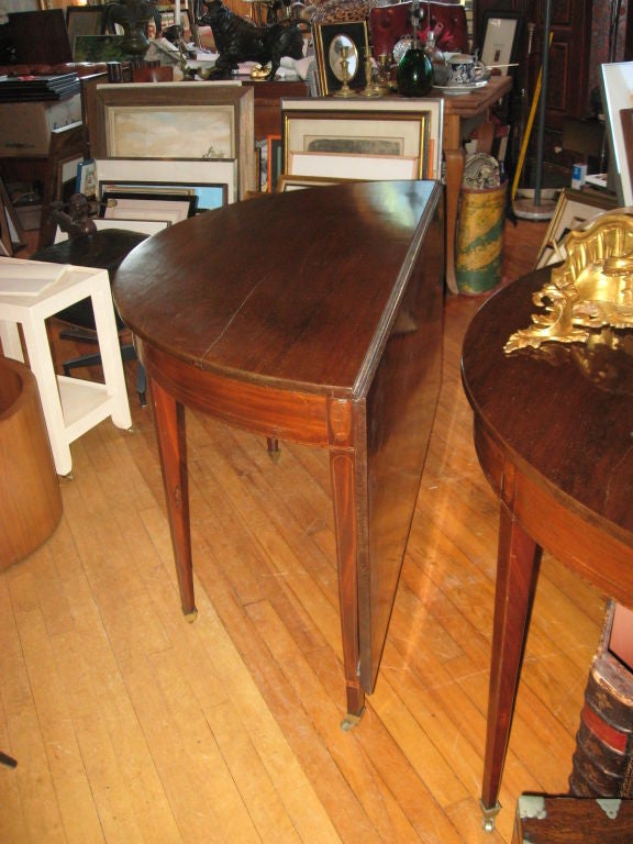 A wonderful pair of period demilune tables with inlaid detail on brass wheels with backdops opening into a 88