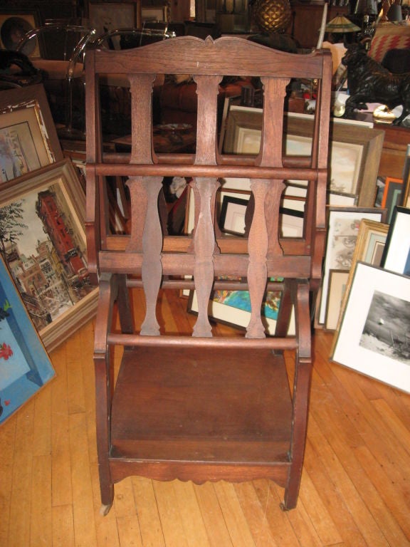 Late 19th century walnut folio stand with under shelve and wooden wheels. Measures: 48" open.