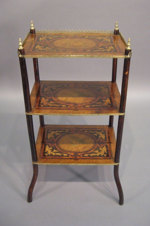 A richly-inlaid Etagere with three tiers, featuring marquetry designs of Floral bouquets with stylized borders on each shelf, and the top section with three-sided Gallery rail between four Brass finials. <br />
<br />
Dating from the end of the