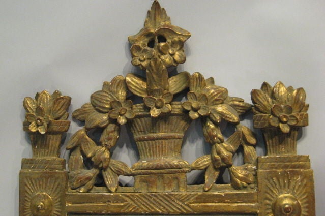 An 18th Century French Louis XVI Gilt-wood Mirror, featuring a flower basket crest and foliate designs. The mirror with original rectangular plate. 





