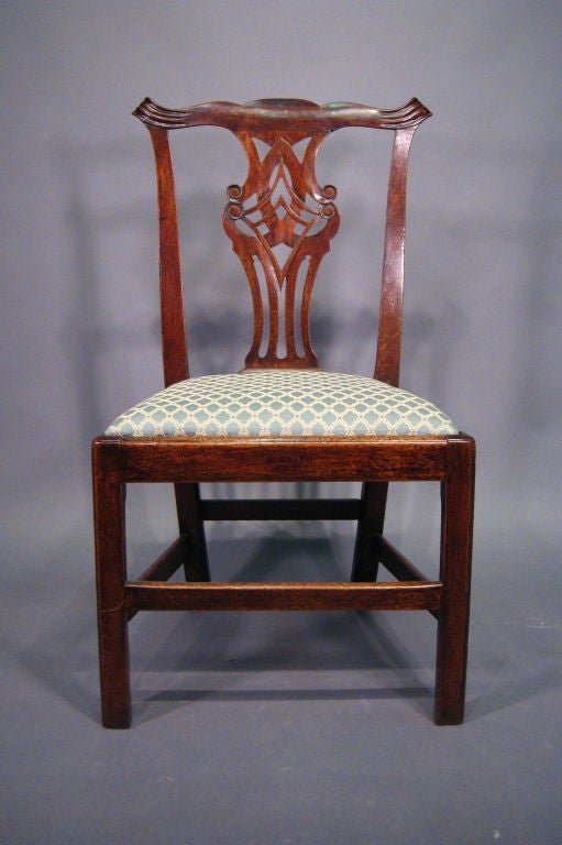 An early George III period side Chair in carved Mahogany. Dating from the third quarter of the 1700s, and English in origin.

The back with pierced interlaced splat in the Chinese Chippendale taste, and featuring a shaped crest rail with up-swept