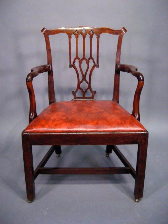 A fine George III period armchair, the frame in solid mahogany with leather drop-in seat. English in origin, dating from the third quarter of the 1700s.

The back with pierced interlaced splat, below a shaped top rail. The drop-in seat flanked by