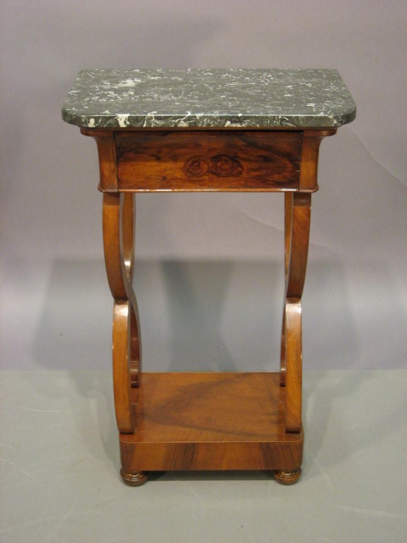 A petite Empire period side table, capped by a mottled gray & white marble top. The table dating from the first quarter of the 1800s, and French in origin.

The marble top conforming to the rectangular Walnut table, above the frieze containing a