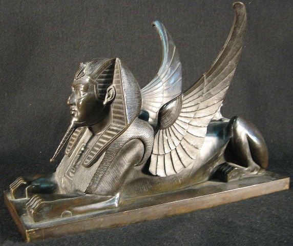 An unusual Bronze sculpture of a Winged Sphinx, cast and finely patinated. The body with an angular design, and detailed with Hieroglyphics & other 