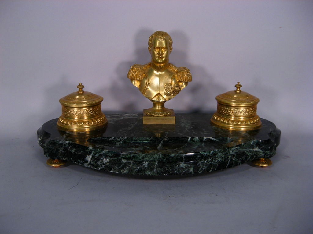  Encrier set, the richly-veined Verde Antico Marble platform mounted with a pair of gilt-Bronze inkwells. These flanking a finely-cast bust of Napoleon in military dress. 

The gilt-bronze finely crafted, with intricate border designs and Napoleon's