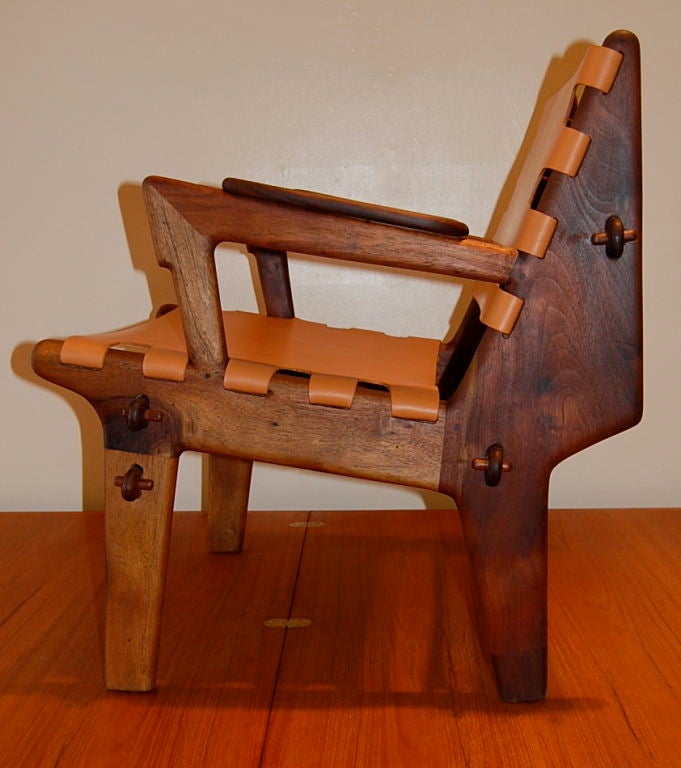 Engaging handmade studio chair from Latin America, of what appears  to  be made out of Cabano, a tropical wood with a reddish hue and figurative grain. The  unique joinery to the frame and the peg attachments to the hides along with a  great
