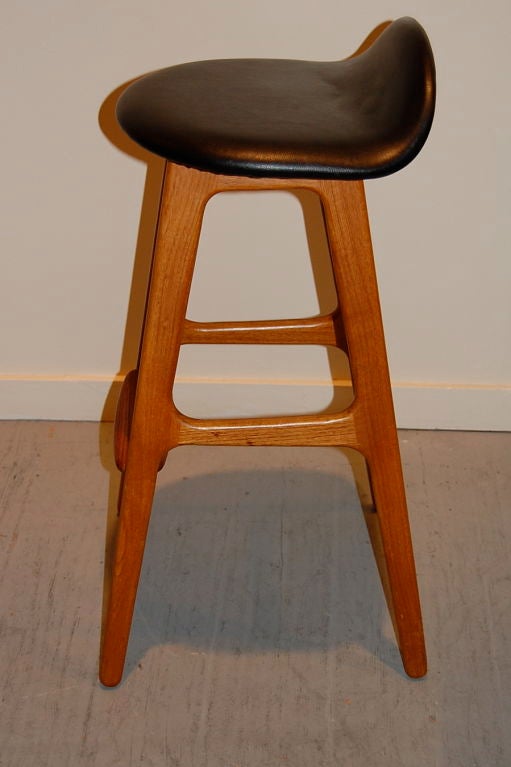 Modern stools by Danish designer Erik Buck, with a sweeping form seat resting on teak fames accented with a rosewood foot rest. Sold as a pair
