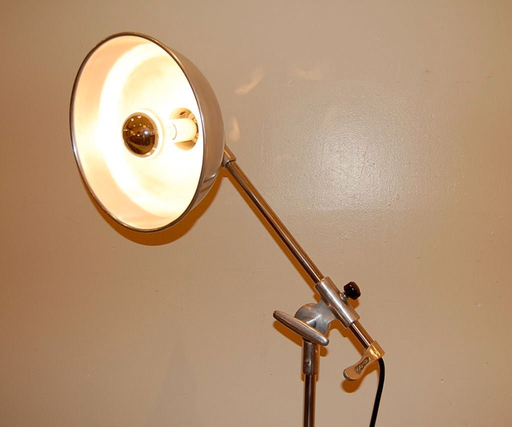 Medical floor light with an adjustable height stem as well as a adjustable arm, the  knobs and switch are of bakelite. The lamp can be articulated in various ways, i.e. the lamp arm can be moved up and down as well as turned 360 degrees and the base